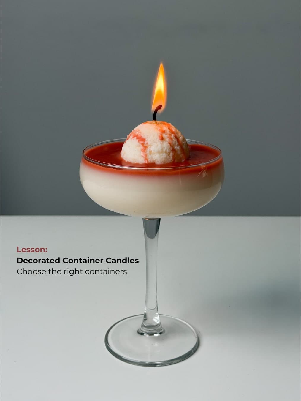 Decorated container candle in a coupe glass
